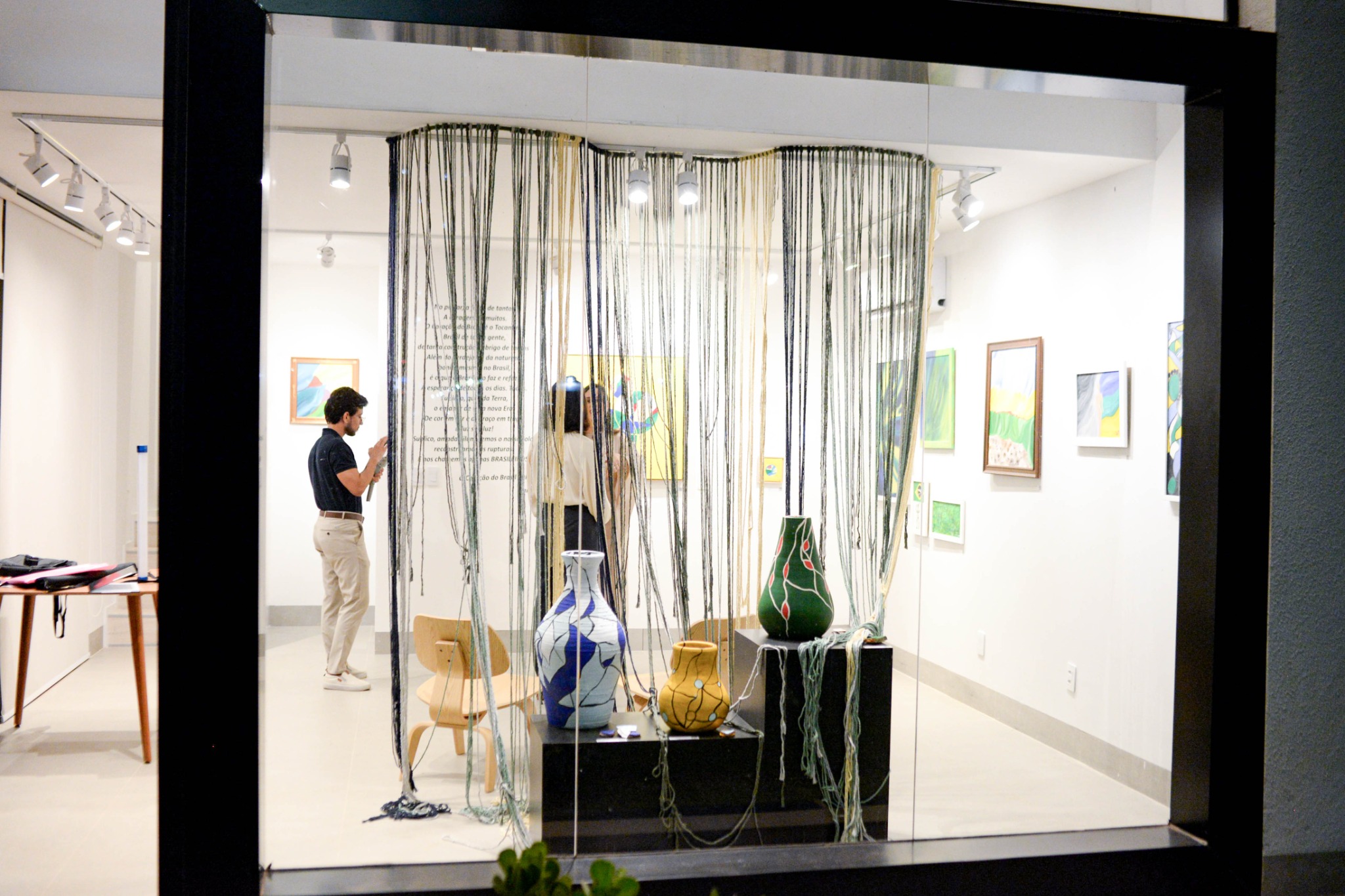 Vista da Galeria Salve com visitantes, obras e instalação da exposição de Lara Faez
